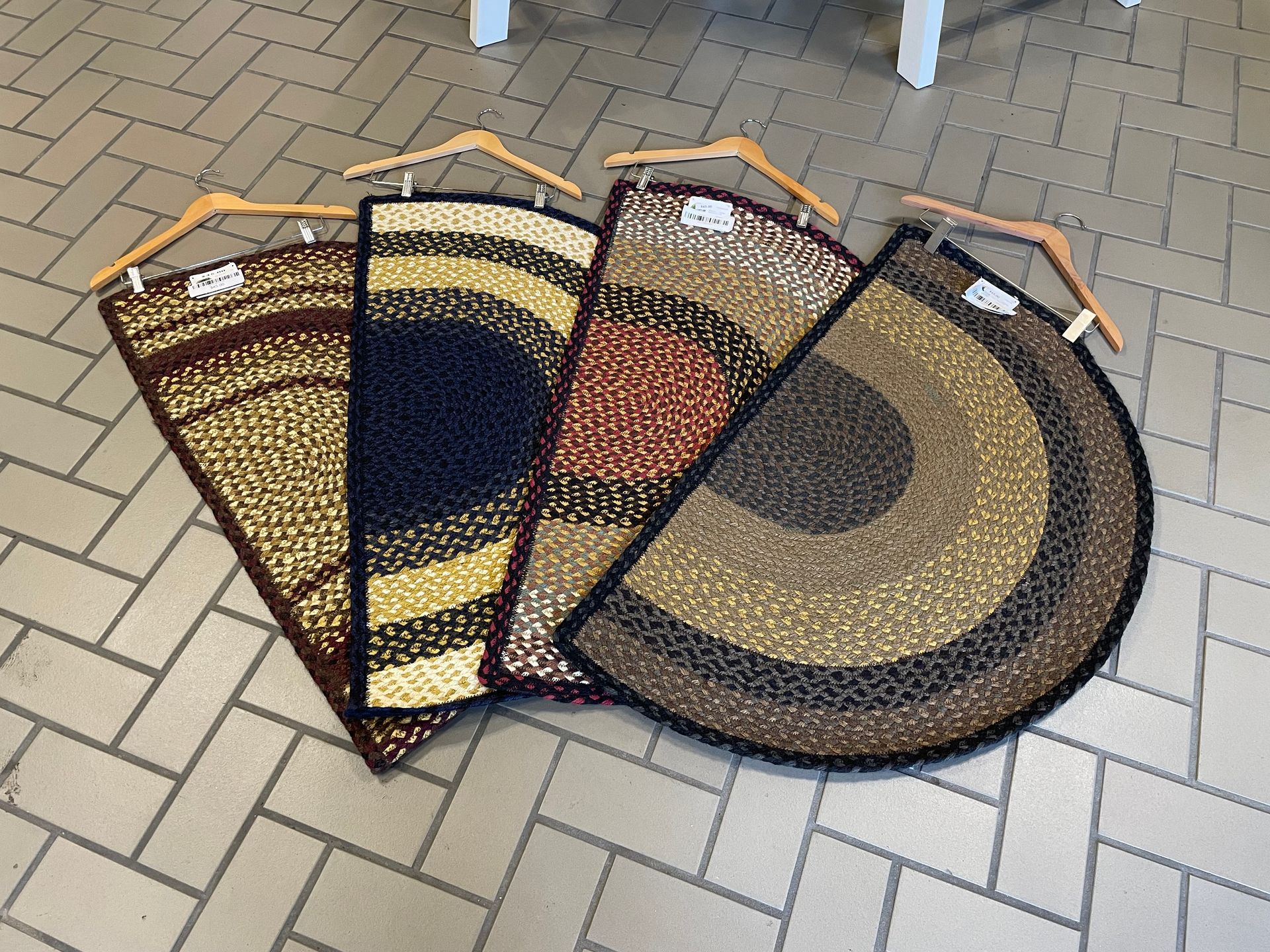 Three rugs are stacked on top of each other on a brick floor.