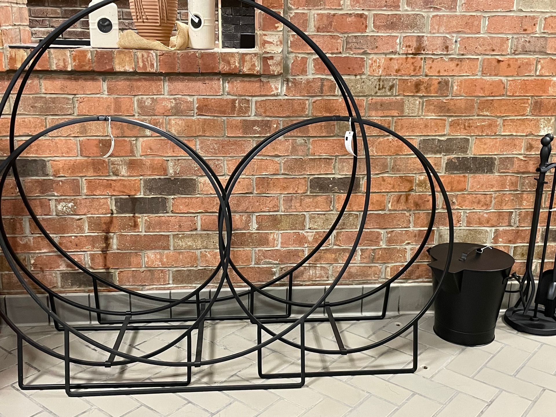 A brick wall with a bunch of metal circles in front of it.