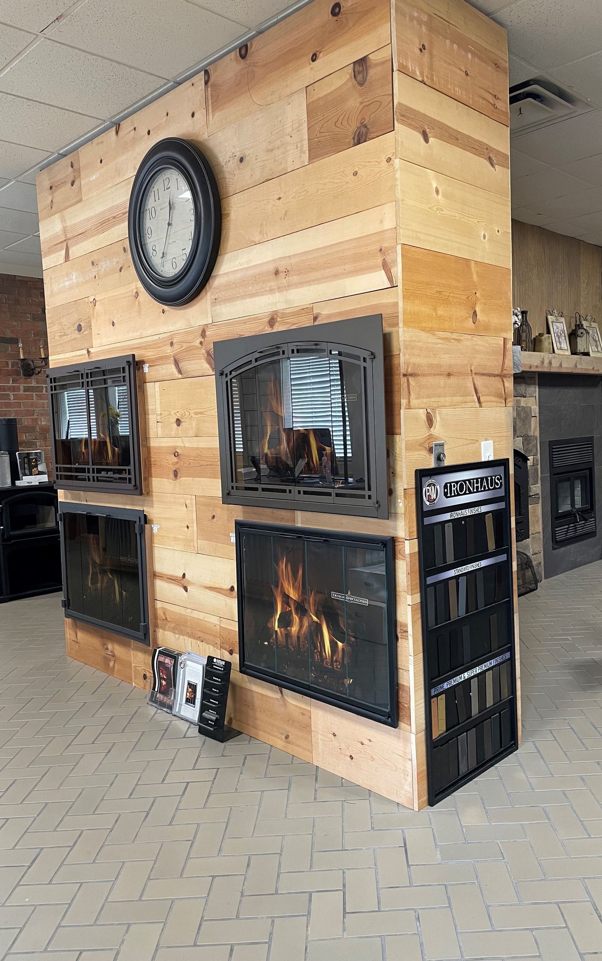 There is a fireplace in the middle of the room with a clock on the wall.