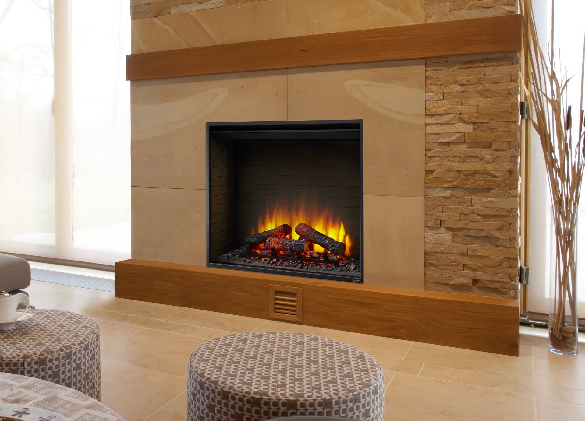 A living room with a fireplace and two ottomans.