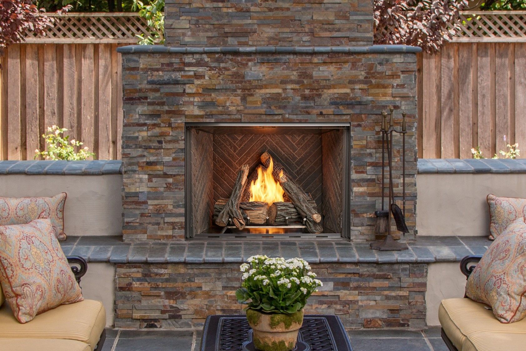 There is a fireplace in the backyard with a potted plant in front of it.