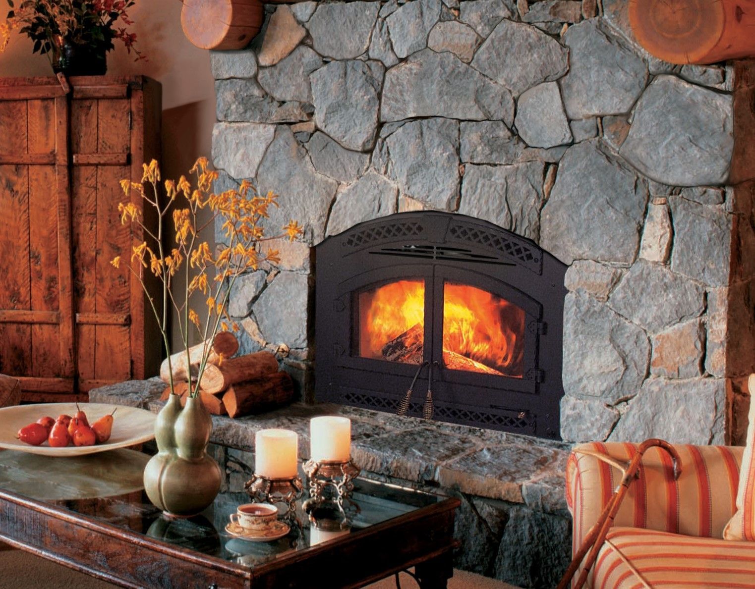A living room with a stone fireplace and a coffee table