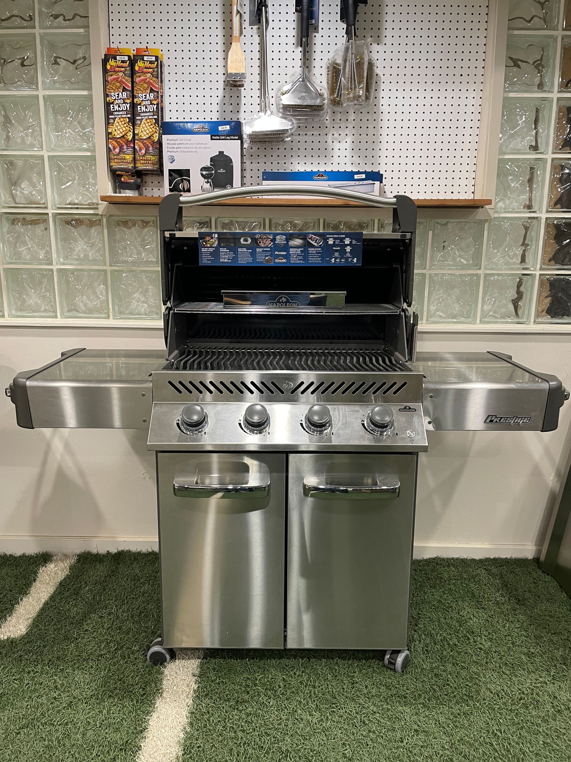 A stainless steel grill is sitting on top of a green carpet in a room.