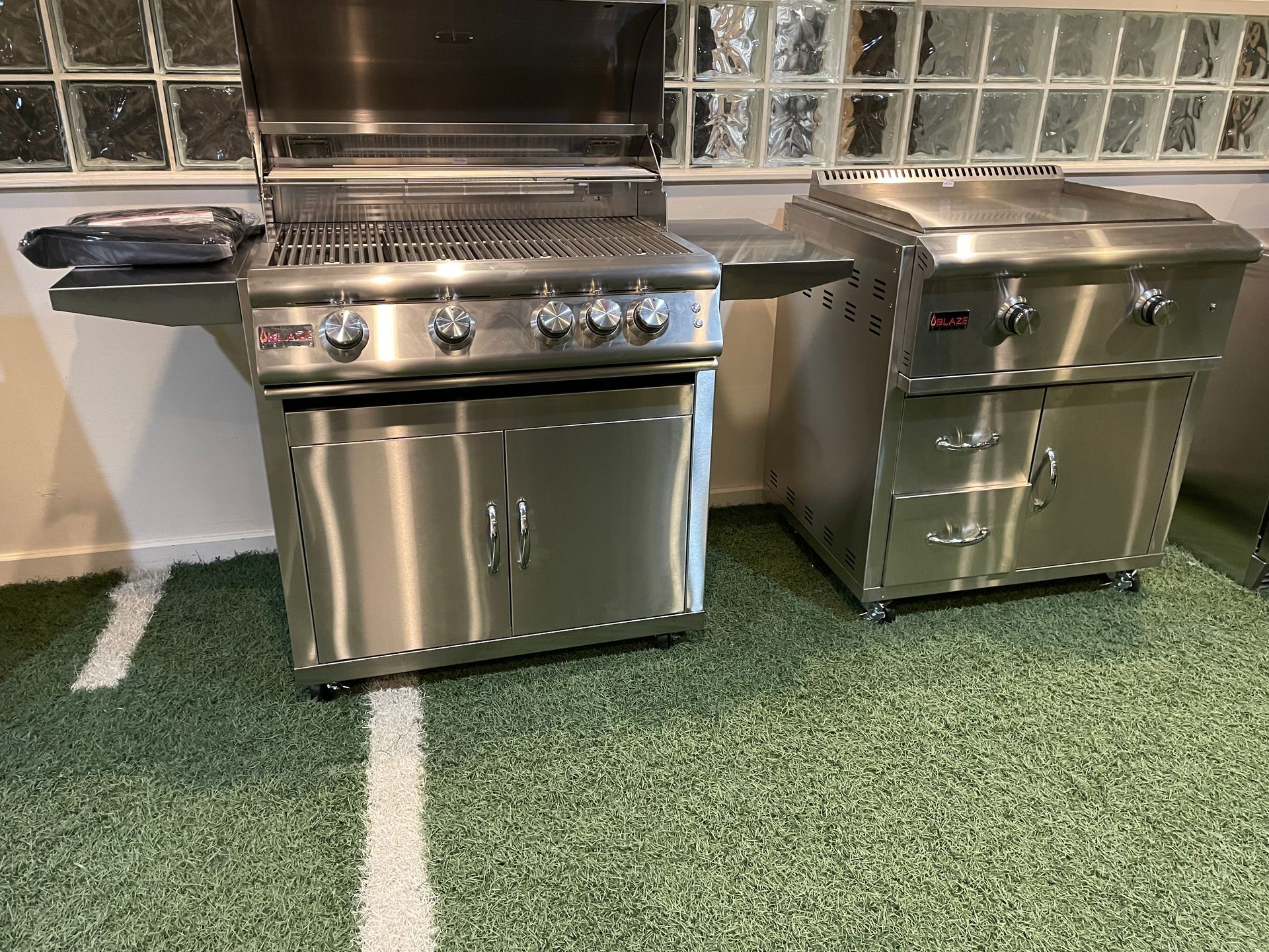 Two stainless steel grills are sitting on top of a football field.