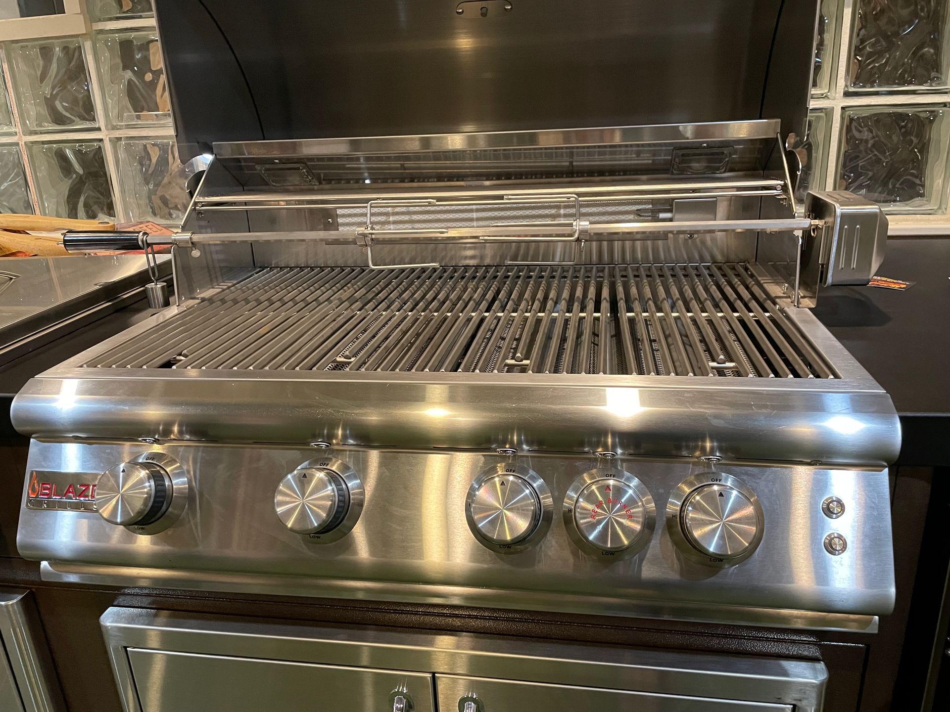 A stainless steel grill is sitting on a counter in a kitchen.