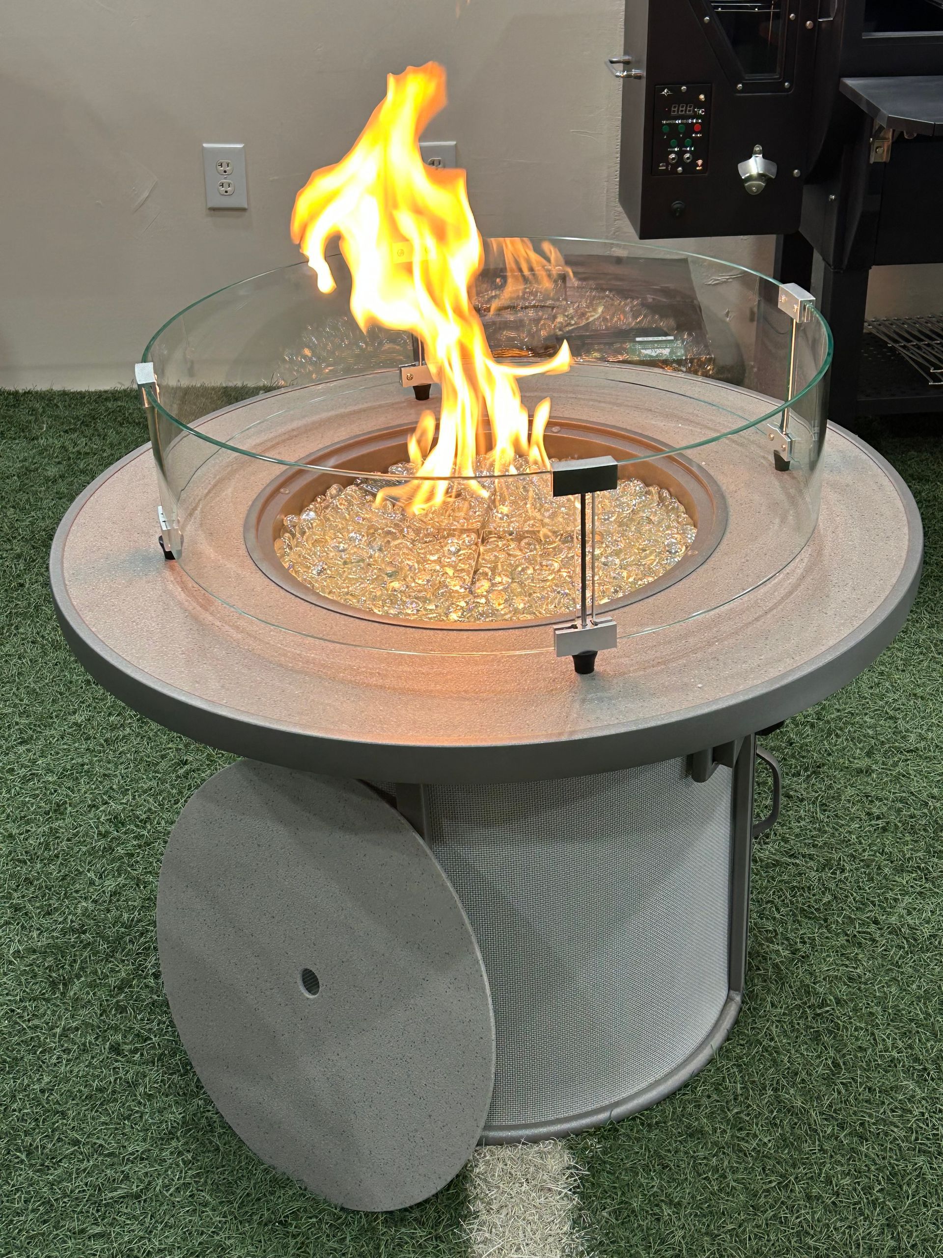 A fire pit is sitting on top of a green carpet.