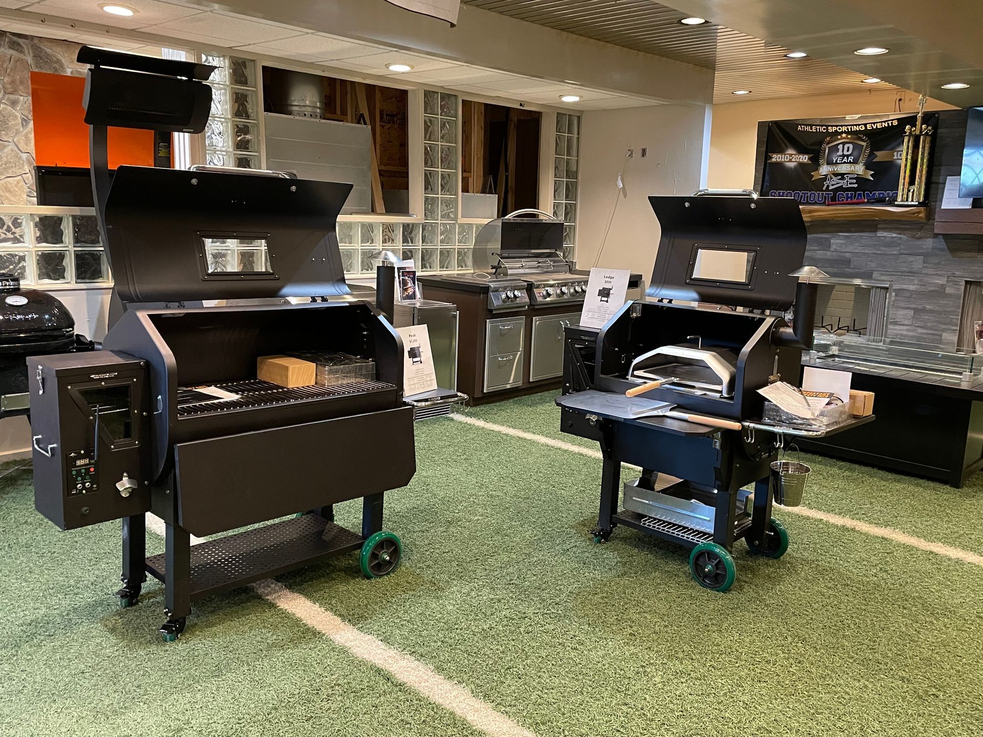 Two grills are sitting on a green carpet in a room.