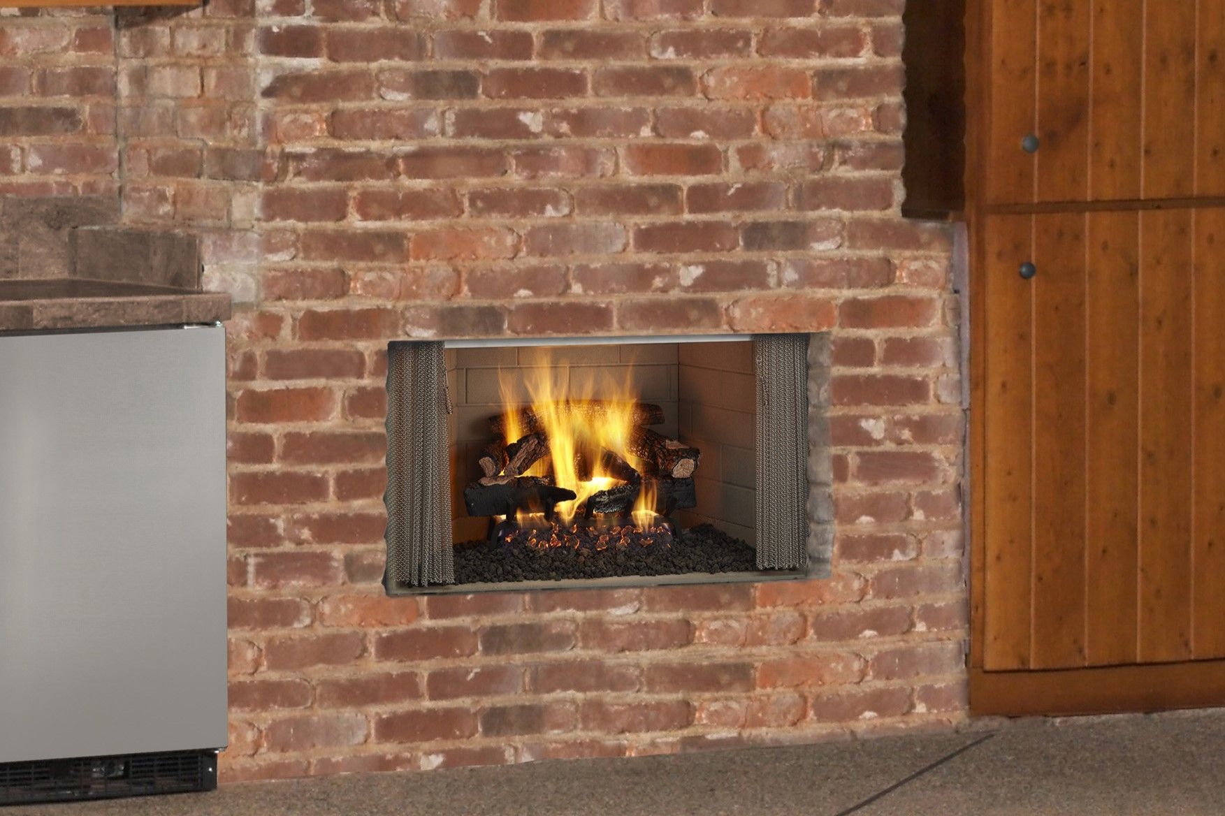 A fireplace is built into a brick wall in a kitchen.
