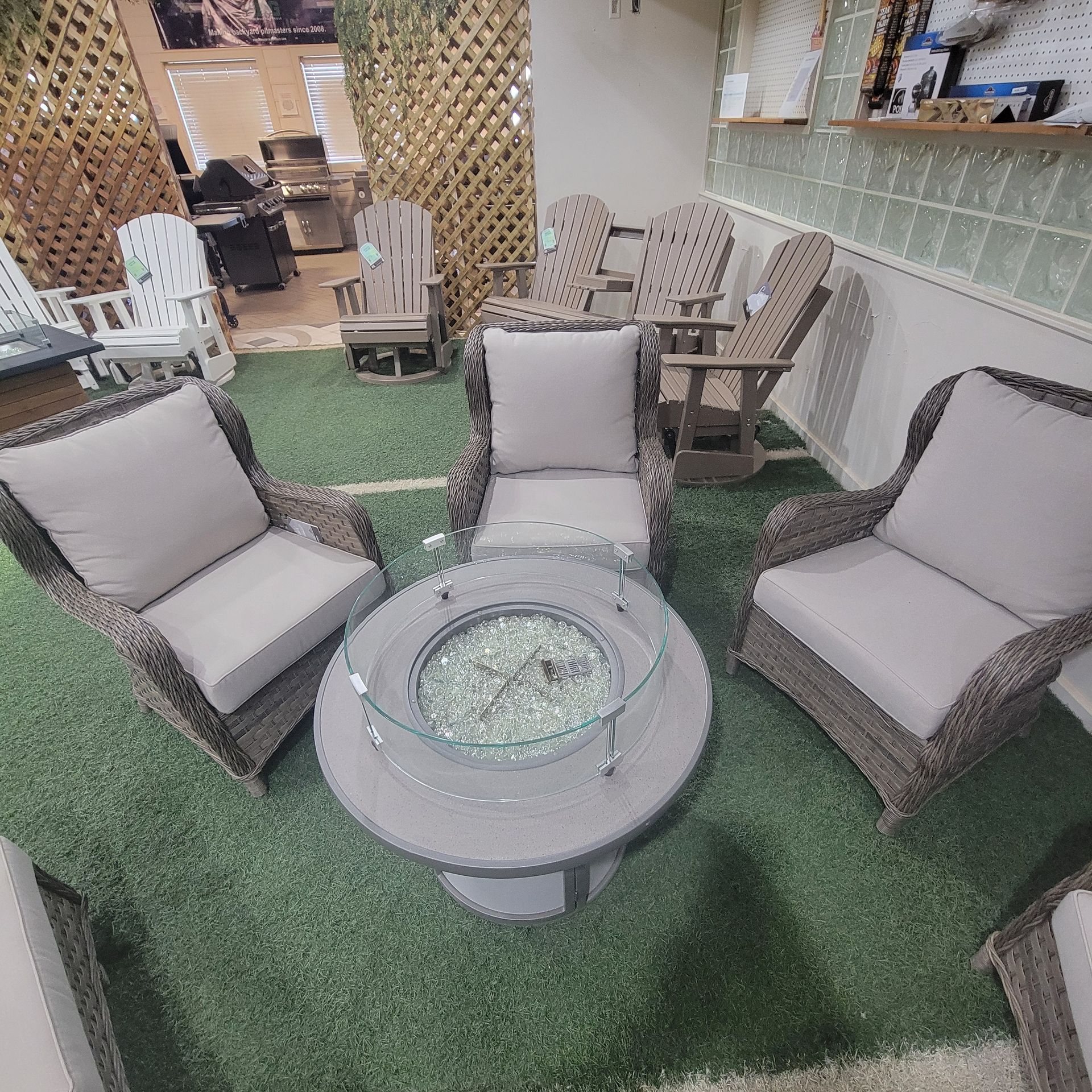 A group of chairs and a table with a fire pit in the middle.