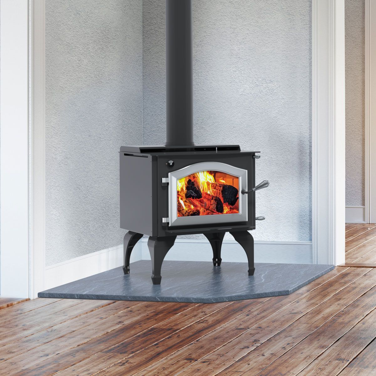 A wood stove is installed on a wooden floor in a room.