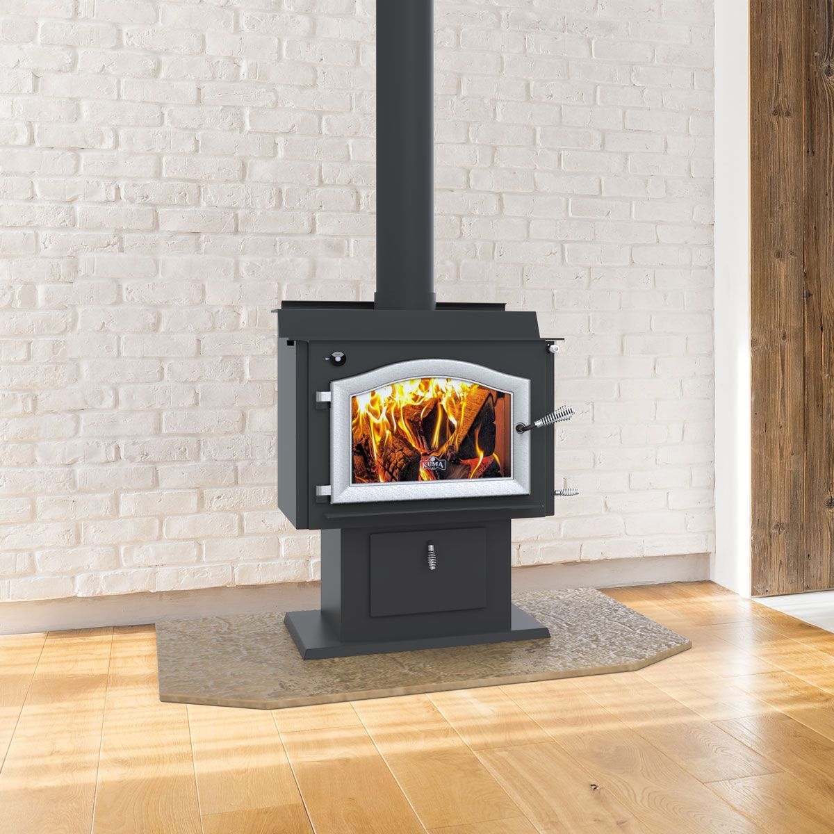 A wood stove in front of a white brick wall.