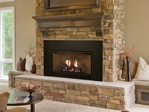 A living room with a fireplace and a stone wall