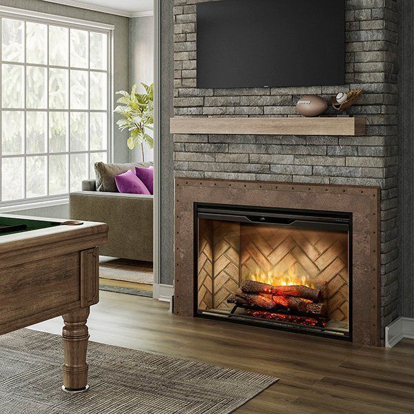Modern living room with brick fireplace, TV, sofa by window, and pool table edge in foreground