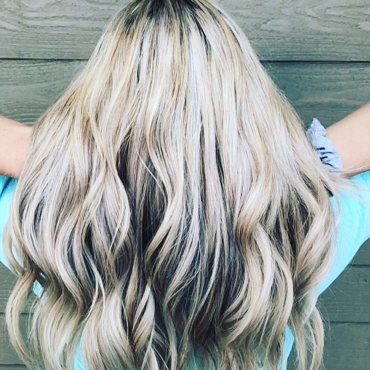 A woman with long blonde hair is wearing a blue shirt.