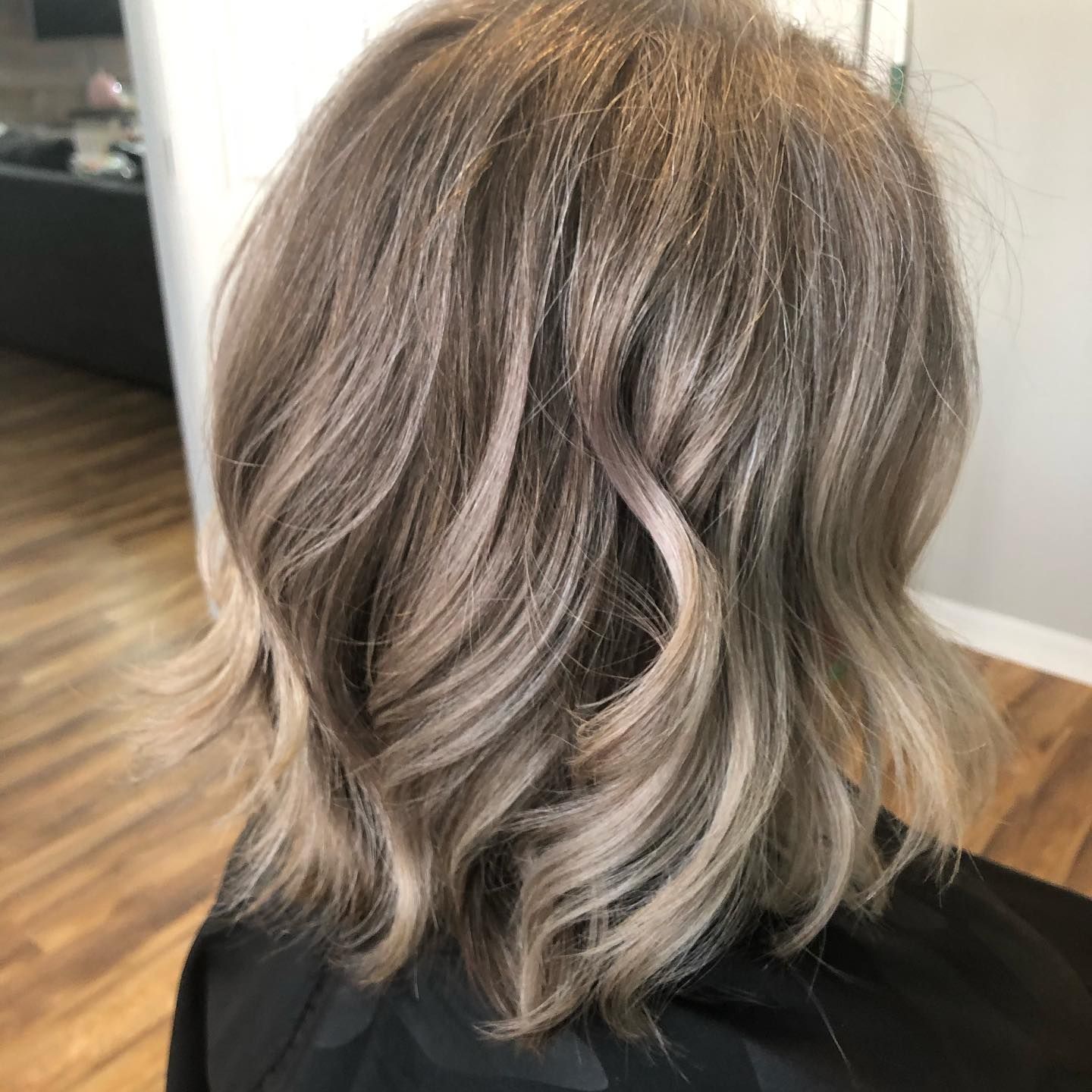A woman with blonde hair is sitting in a chair with her back to the camera.
