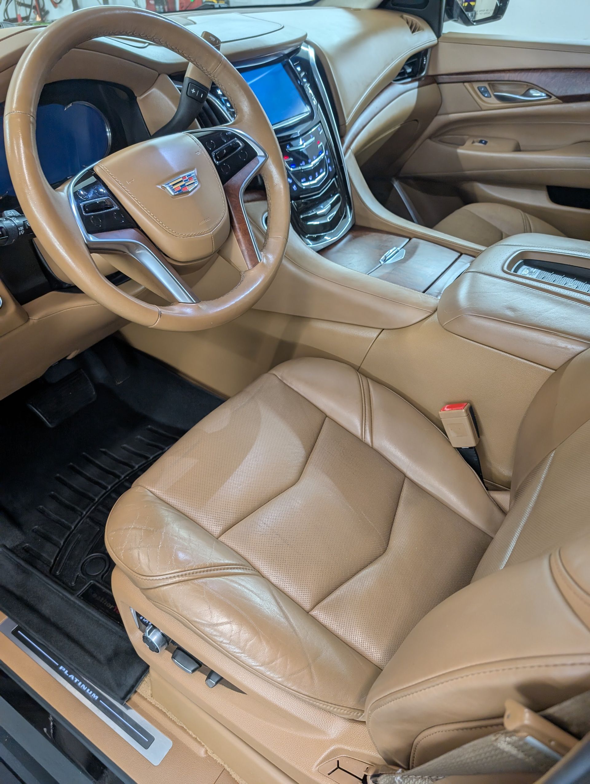 Beige luxury car interior with leather seats and steering wheel, viewed from the driver’s side