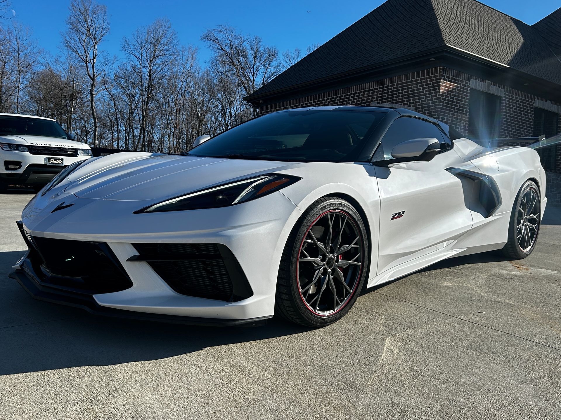 White Chevrolet Corvette parked outside a building on a sunny day