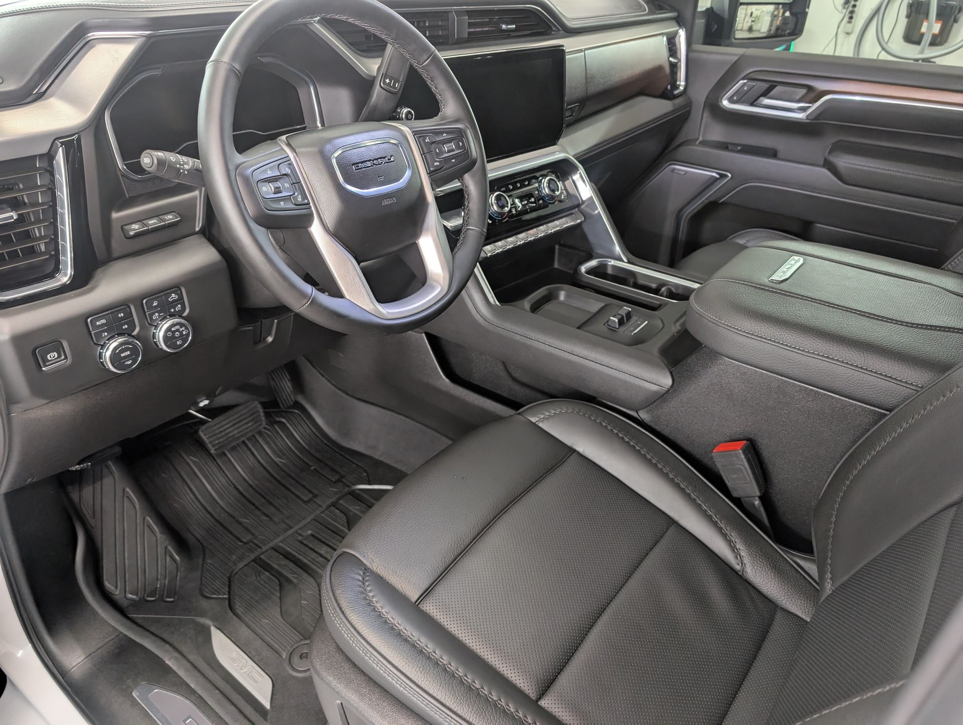 Interior of a luxury pickup truck with black leather seats, steering wheel, and center console close-up