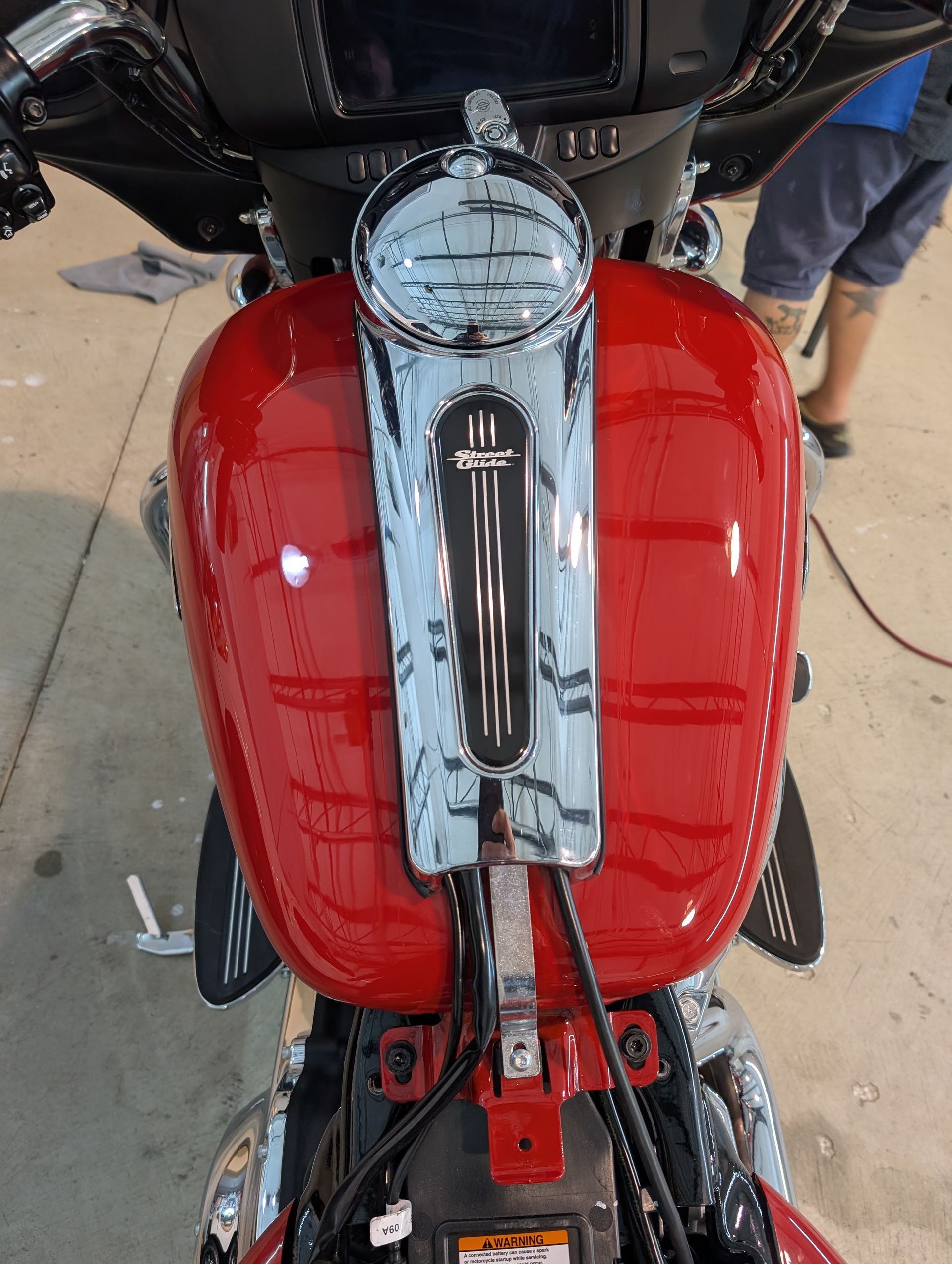 Red motorcycle fuel tank and chrome center console viewed from above.