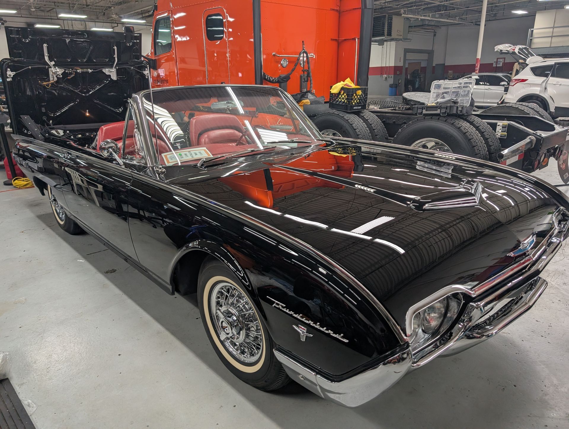 Black classic convertible sports car with red interior in an indoor showroom