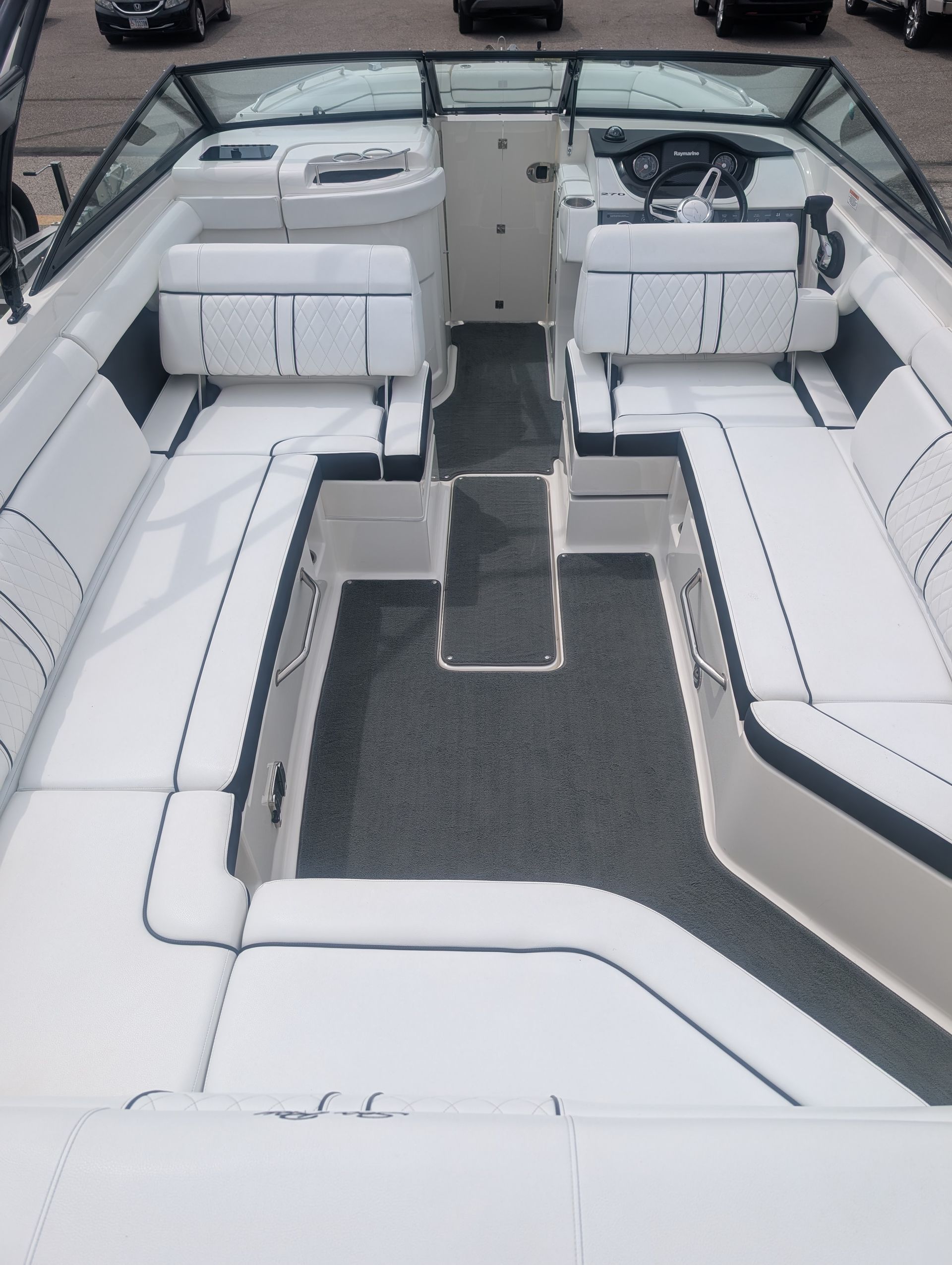 White and gray boat seating area with a central walkway and rear helm console