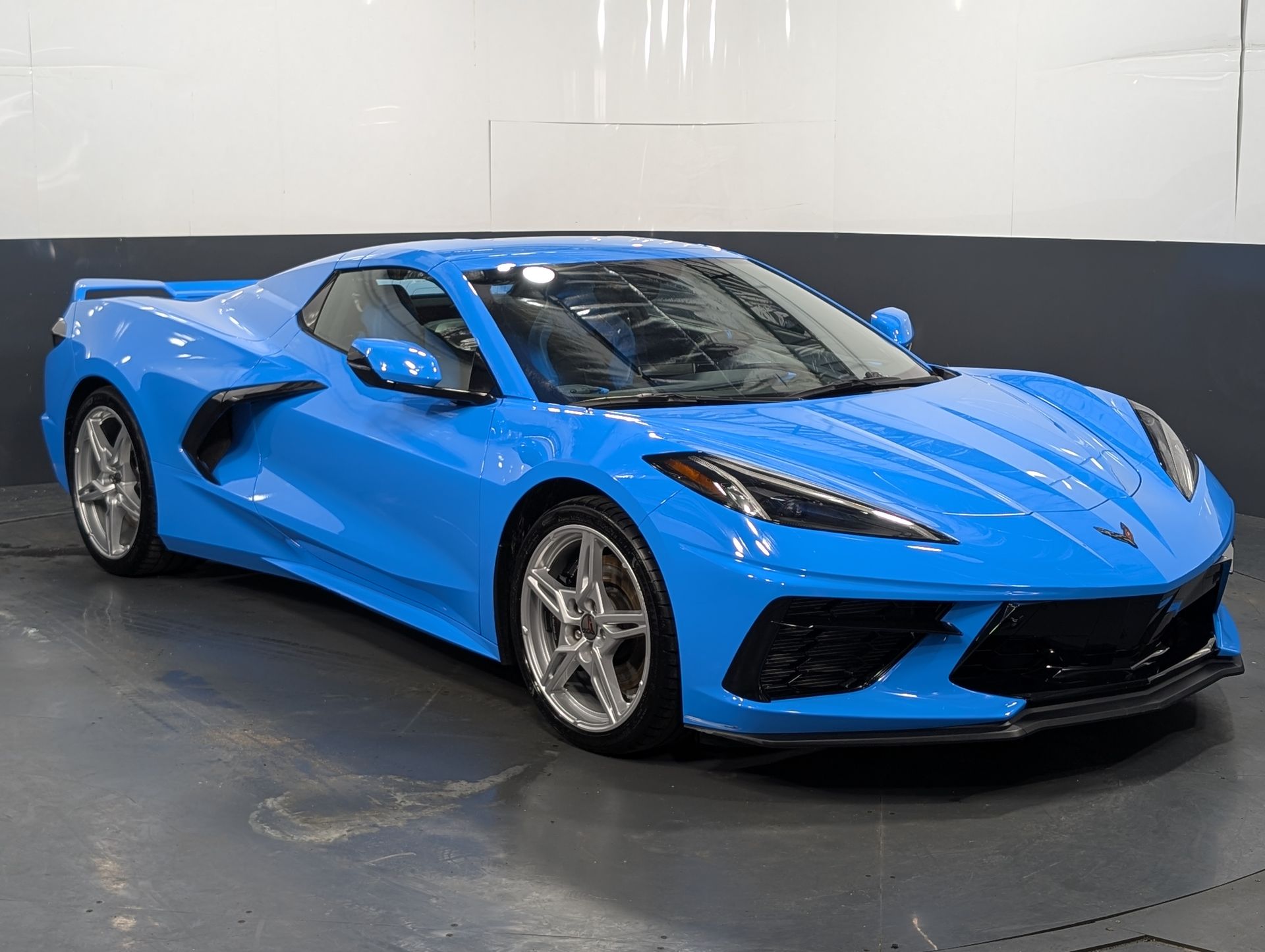 Blue sports car in a studio, shown from the front-left angle.
