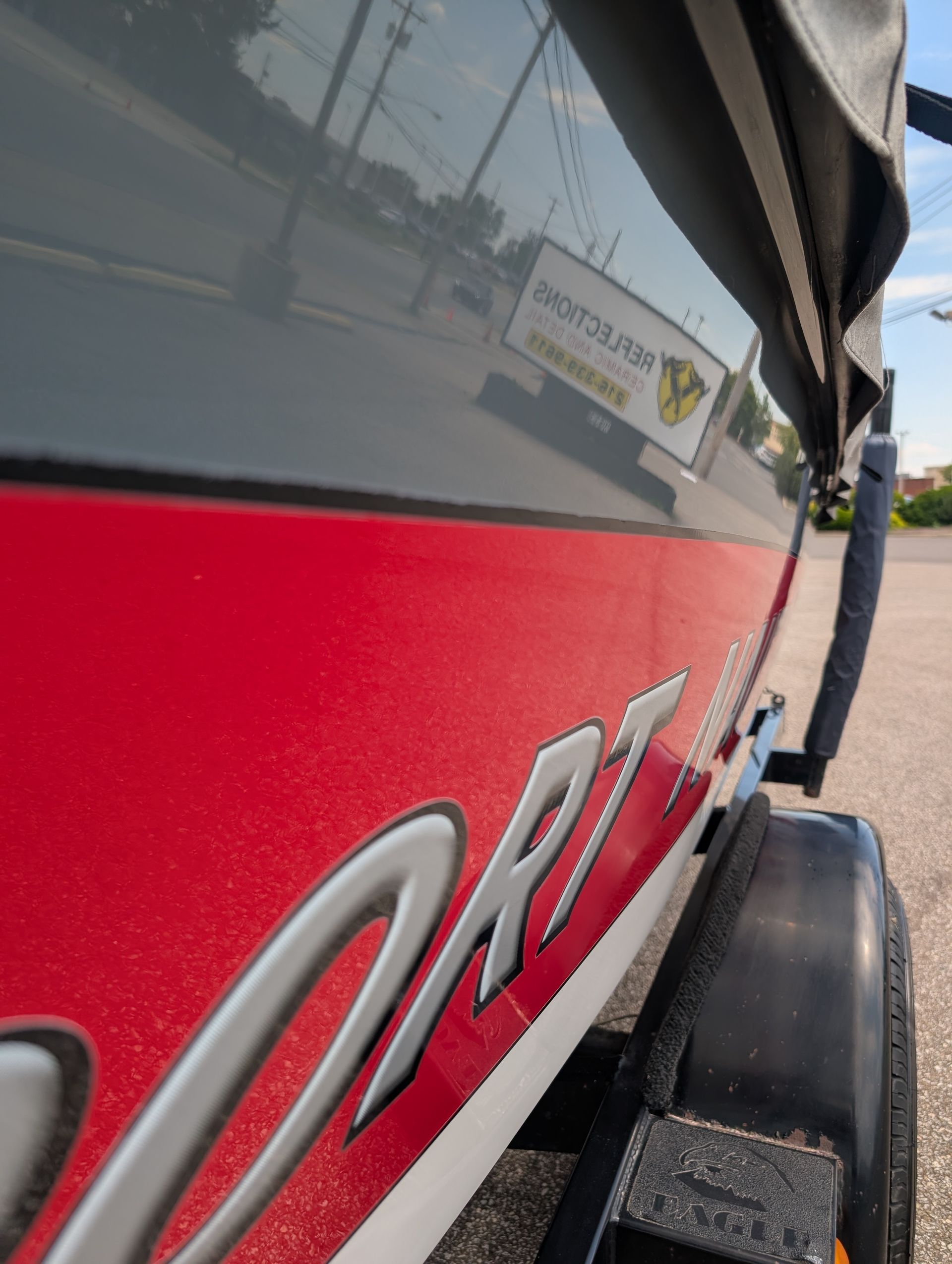 Close-up of a red off-road vehicle with black fender and white lettering on the side.