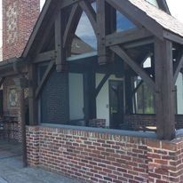 Brick building exterior with dark wooden beams and large windows.
