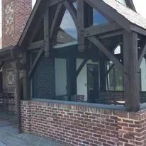 Brick building with dark wood frame and large window.