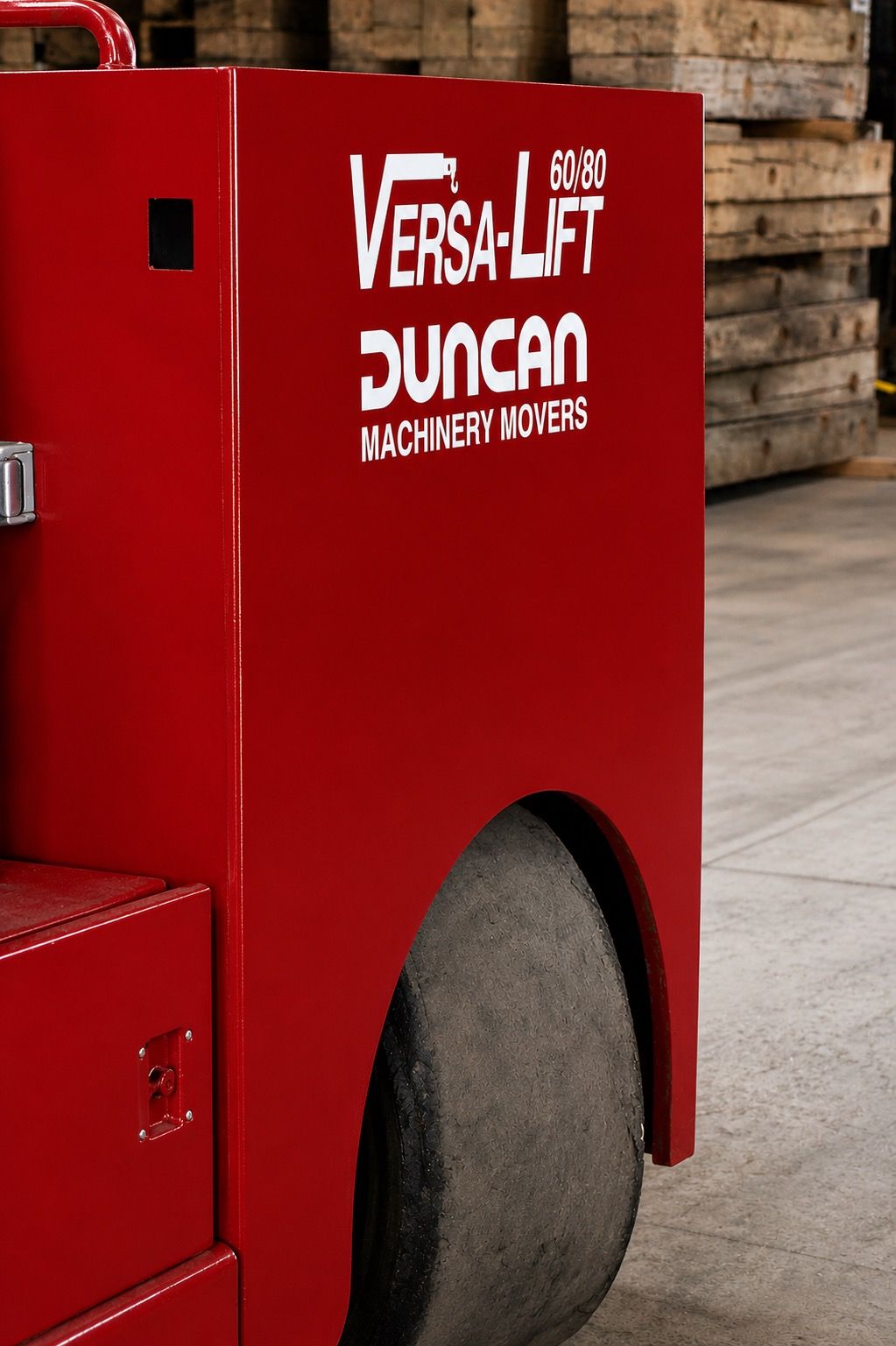 Red VersaLift machine with a large black tire in a workshop setting