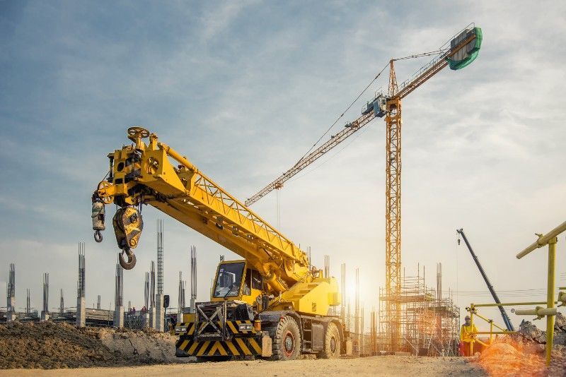A yellow crane is sitting on top of a construction site.