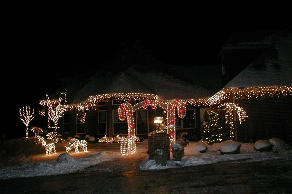 House with Christmas lights, including candy canes and reindeer, illuminated against a dark sky.