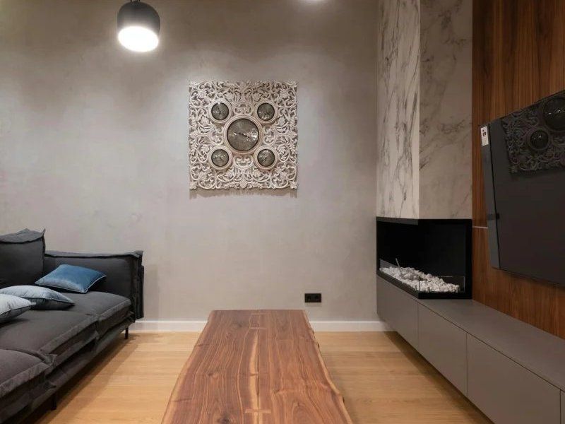 Minimalist bedroom with bed, wood floor, wall art, and a modern fireplace.