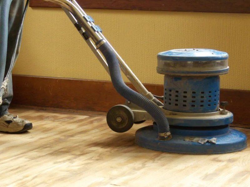 Floor buffer polishing a wooden floor near a yellow wall