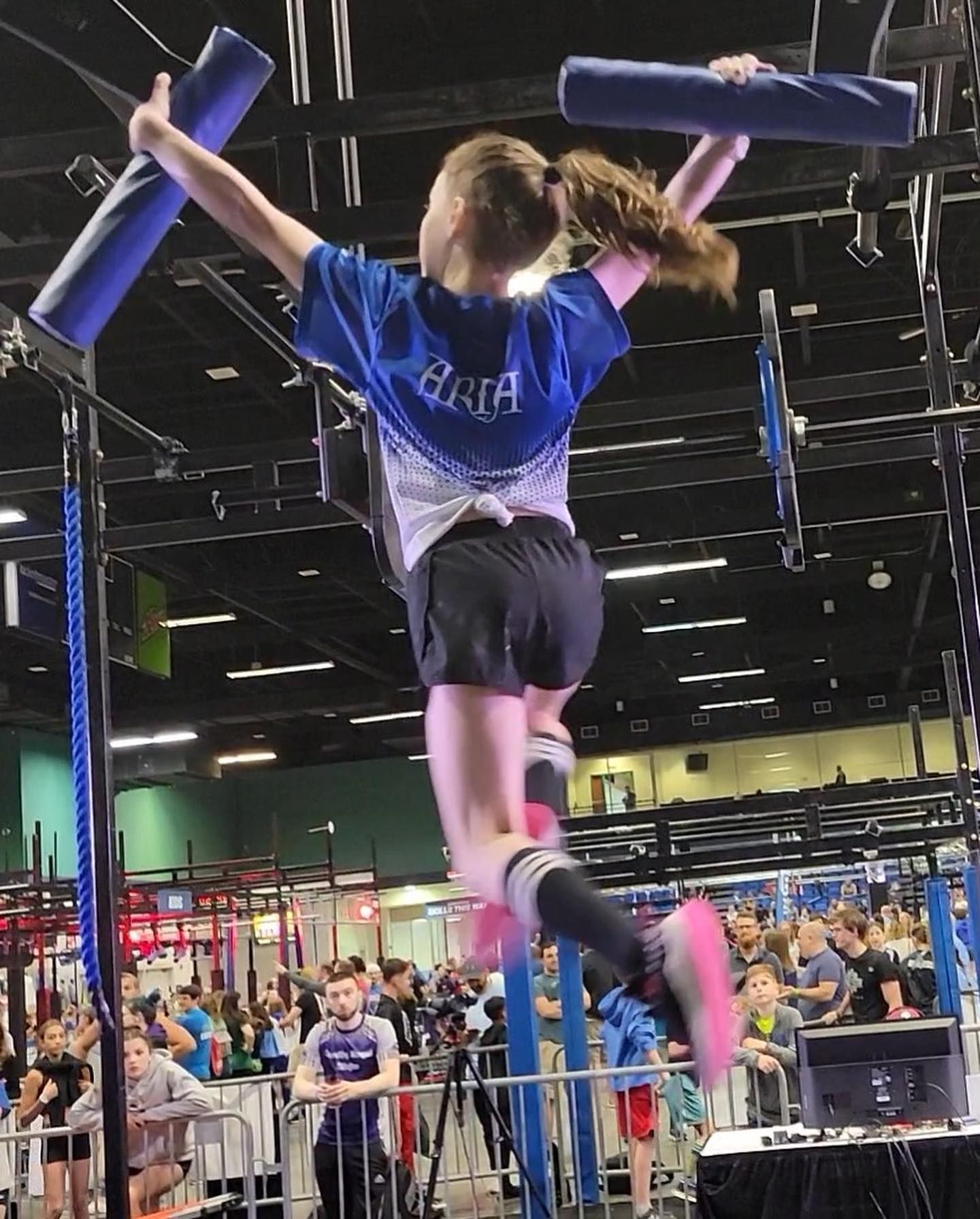 A girl in a blue shirt with the word aria on it