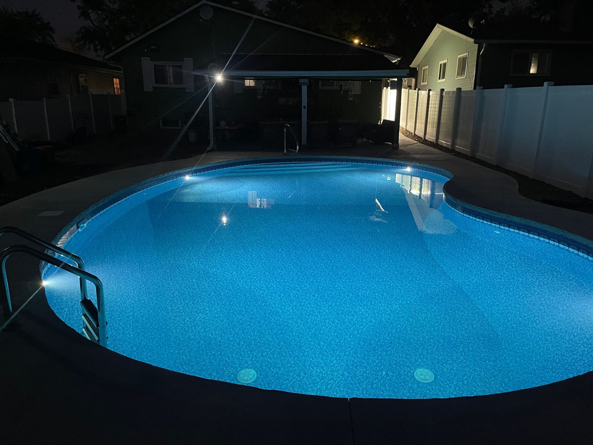 A large swimming pool is lit up at night