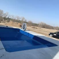 A car is parked next to a large swimming pool.