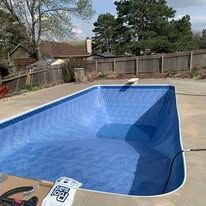 A large swimming pool is being built in a backyard.
