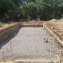 A large swimming pool is being built in a backyard.