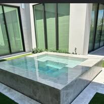 There is a large swimming pool in the backyard of a house.