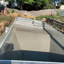 A swimming pool is being built in a backyard.