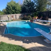 A large swimming pool with a diving board in the backyard.
