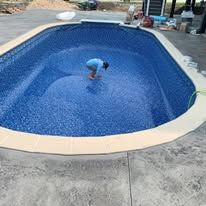 A man is bending over in a large swimming pool.