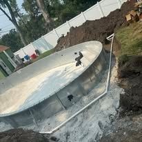 A large swimming pool is being built in a backyard.