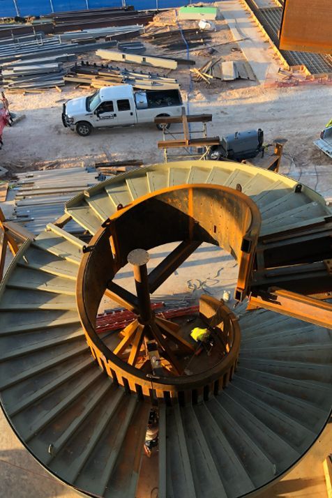 A spiral staircase is being built on a construction site.