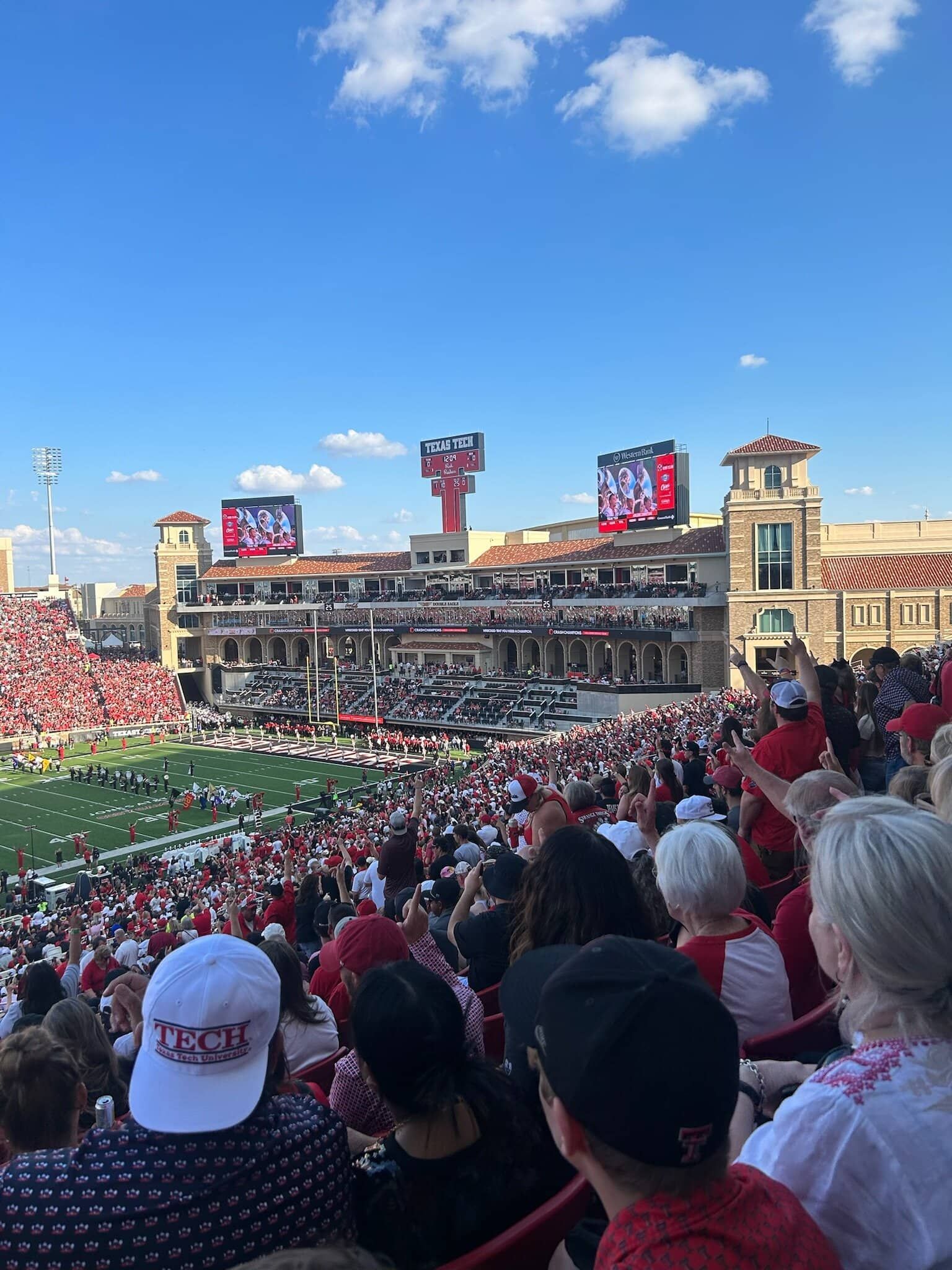 A crowd of people are watching a football game in a stadium.