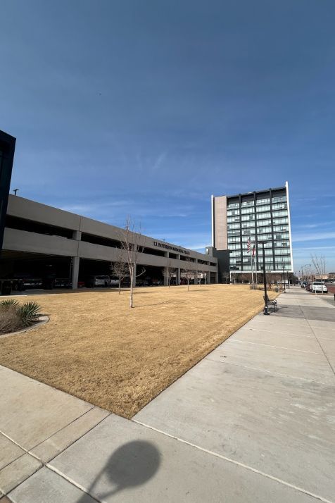 A parking garage with a large building in the background