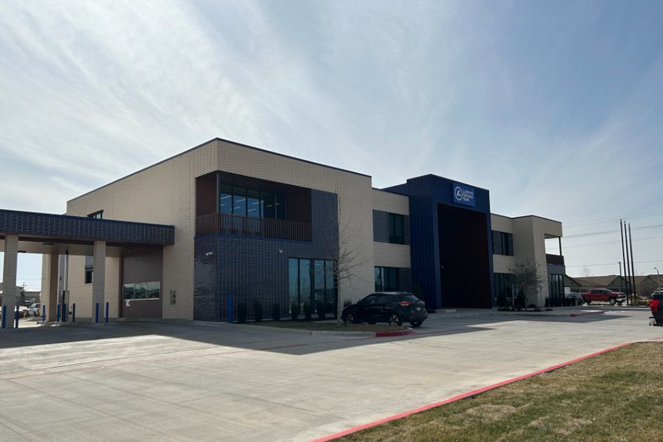 A large building with a lot of windows and a car parked in front of it.