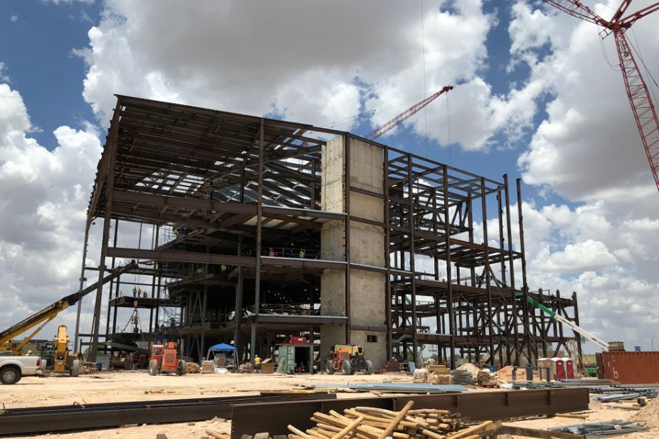 A large building under construction with a crane in the background.