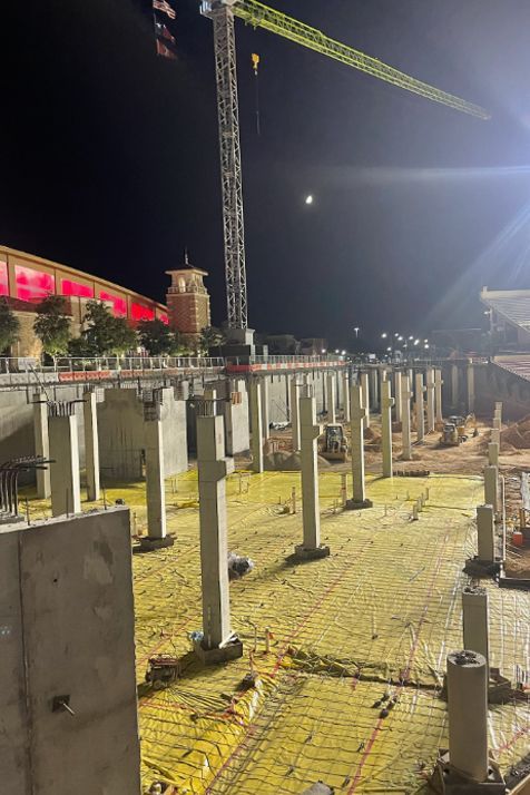 A construction site at night with a crane in the background.